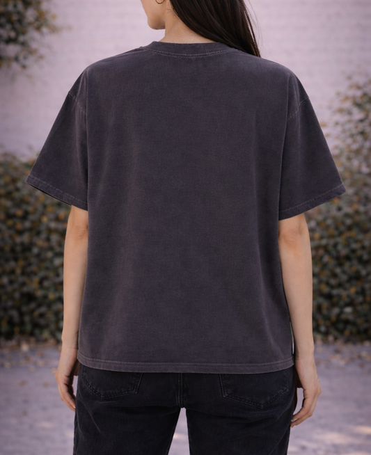 Person wearing a dark gray t-shirt with a blurred background