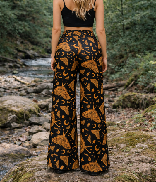 Woman wearing a black and gold celestial luna moth patterned outfit in a forest setting