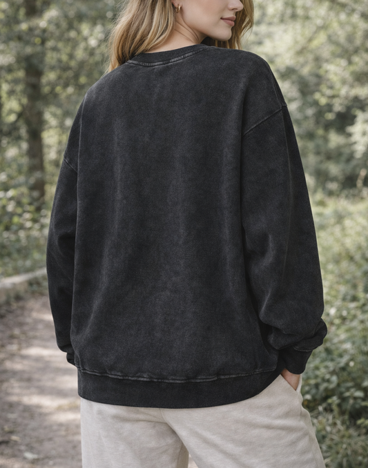 Person wearing a black sweatshirt in a forest setting