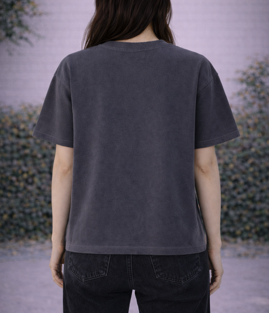 Person wearing a dark gray t-shirt with a blurred background