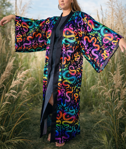 Person wearing a colorful snake-patterned kimono in a natural setting