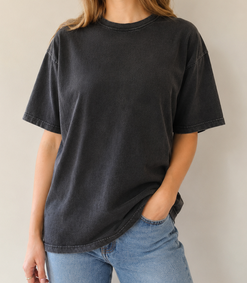Woman wearing a black t-shirt and blue jeans against a plain background