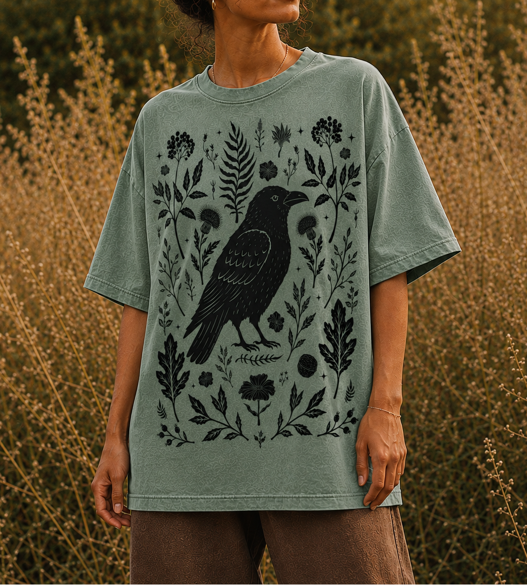 Vintage wash sage green t-shirt with hand-drawn crow and botanical graphic