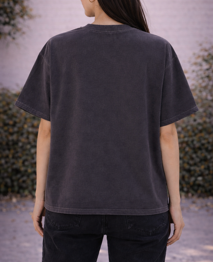 Person wearing a dark gray t-shirt with a blurred background