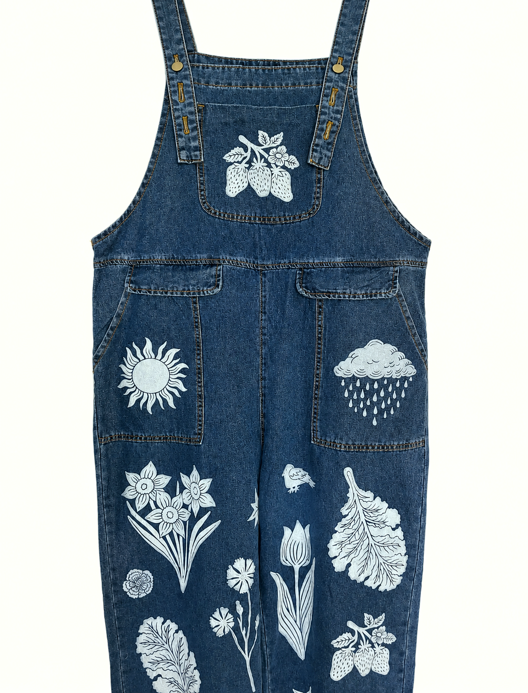 Blue denim overalls with white floral and nature-themed embroidery on a white background