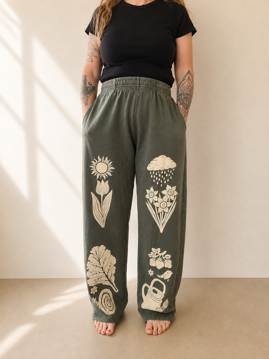 Person wearing green sweatpants with nature-themed designs against a neutral background