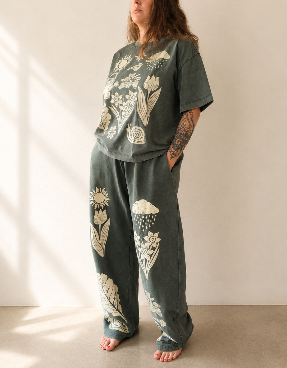 Person wearing a green outfit with nature-themed designs in a minimalistic setting