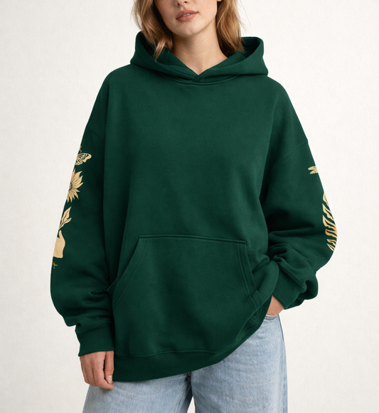 Person wearing a green hoodie with gold designs on a white background