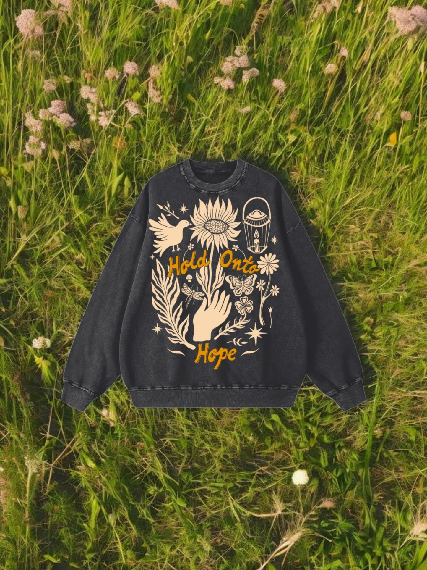 Black sweatshirt with white and yellow designs on a grassy field