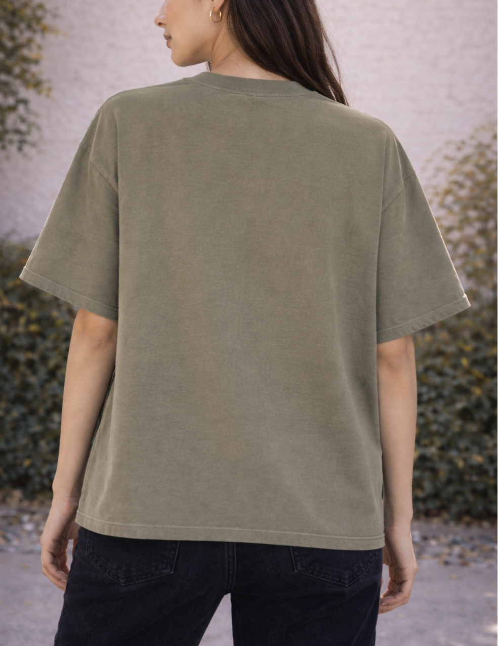 Person wearing an olive green t-shirt with a neutral background