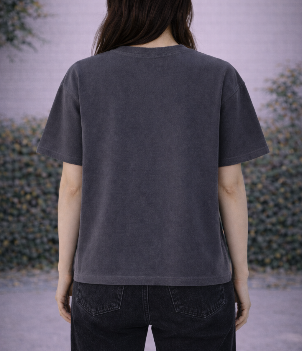 Person wearing a dark gray t-shirt with a blurred background