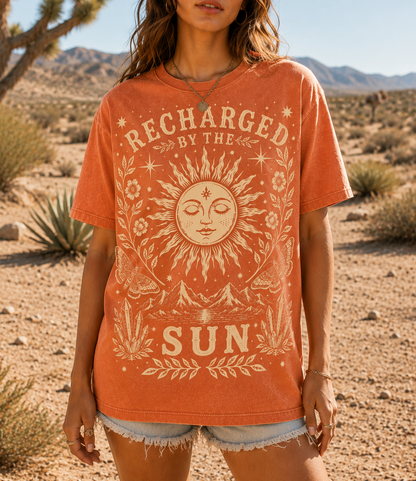 Woman wearing a 'Recharged by the Sun' t-shirt in a desert setting