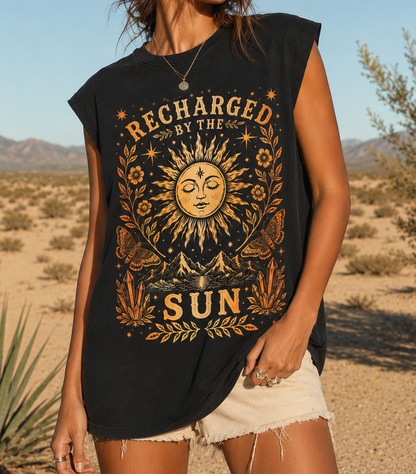 Woman wearing a black sleeveless shirt with sun design and 'Recharged by the Sun' text in a desert setting.