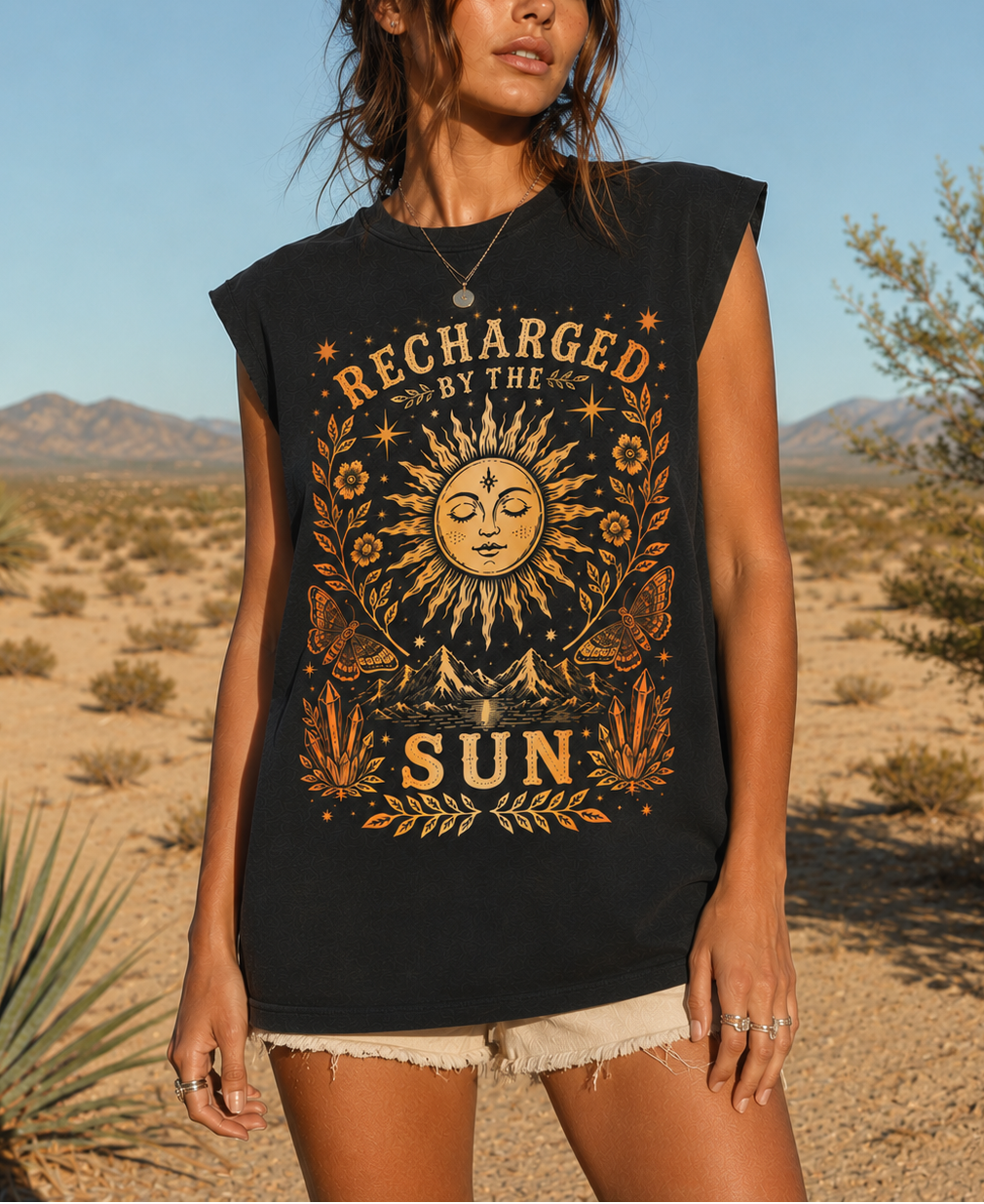 Woman wearing a black sleeveless shirt with sun design and 'Recharged by the Sun' text in a desert setting.