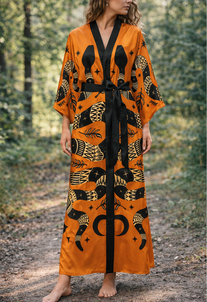 Woman wearing an orange and black snake patterned kimono robe in a forest setting