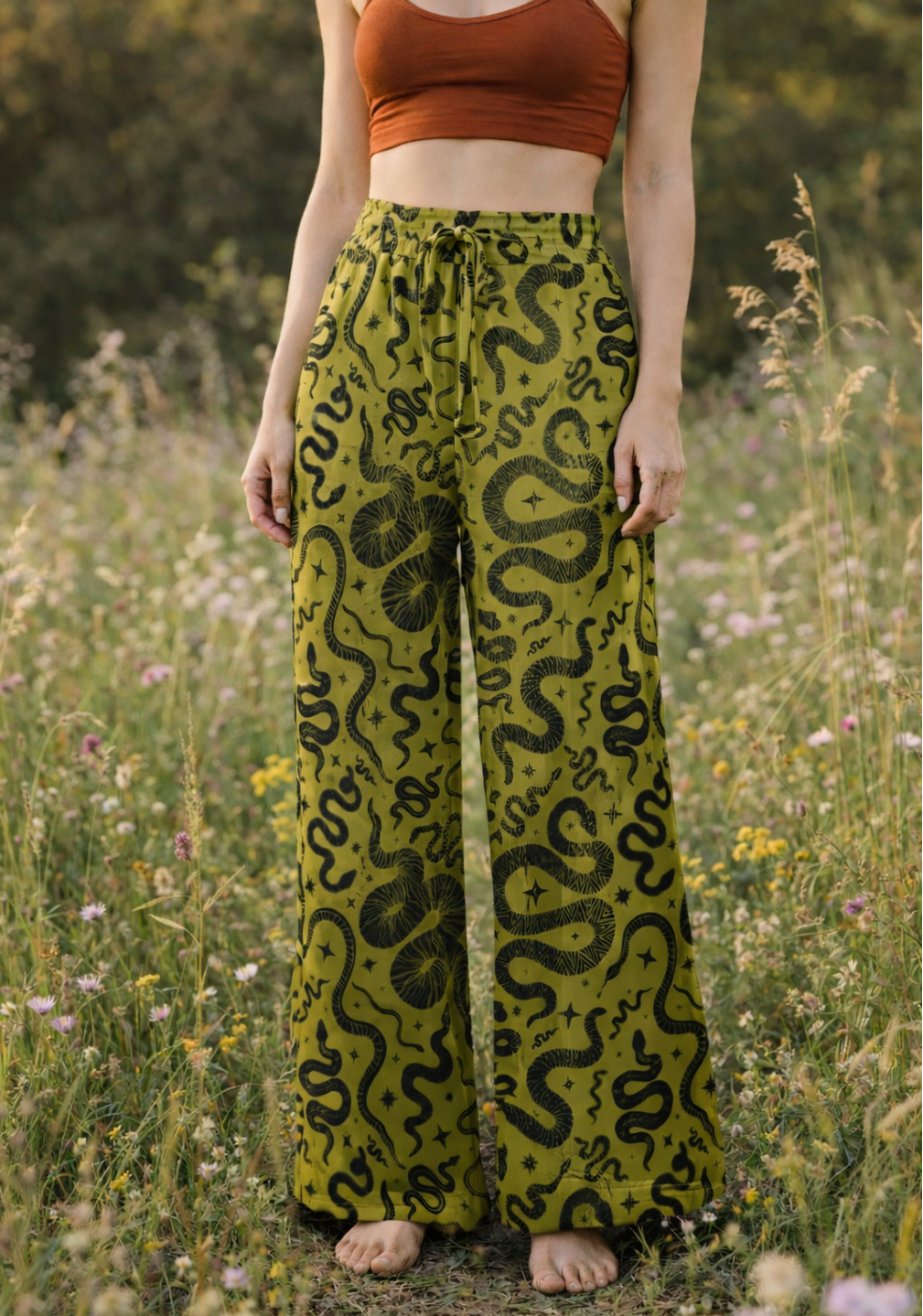 Person wearing green snake print pants in a natural setting