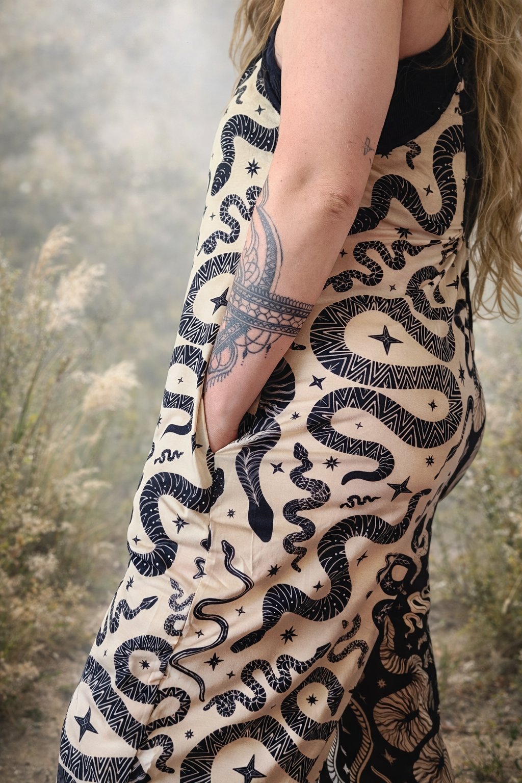 Person wearing a jumpsuit with pockets with snake pattern in a natural setting