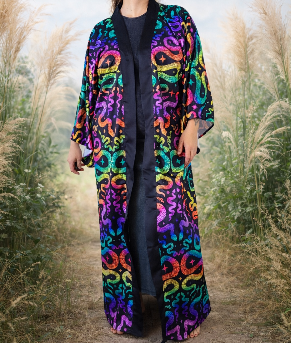 Person wearing a colorful snake patterned kimono robe coat standing in a field of tall grass.