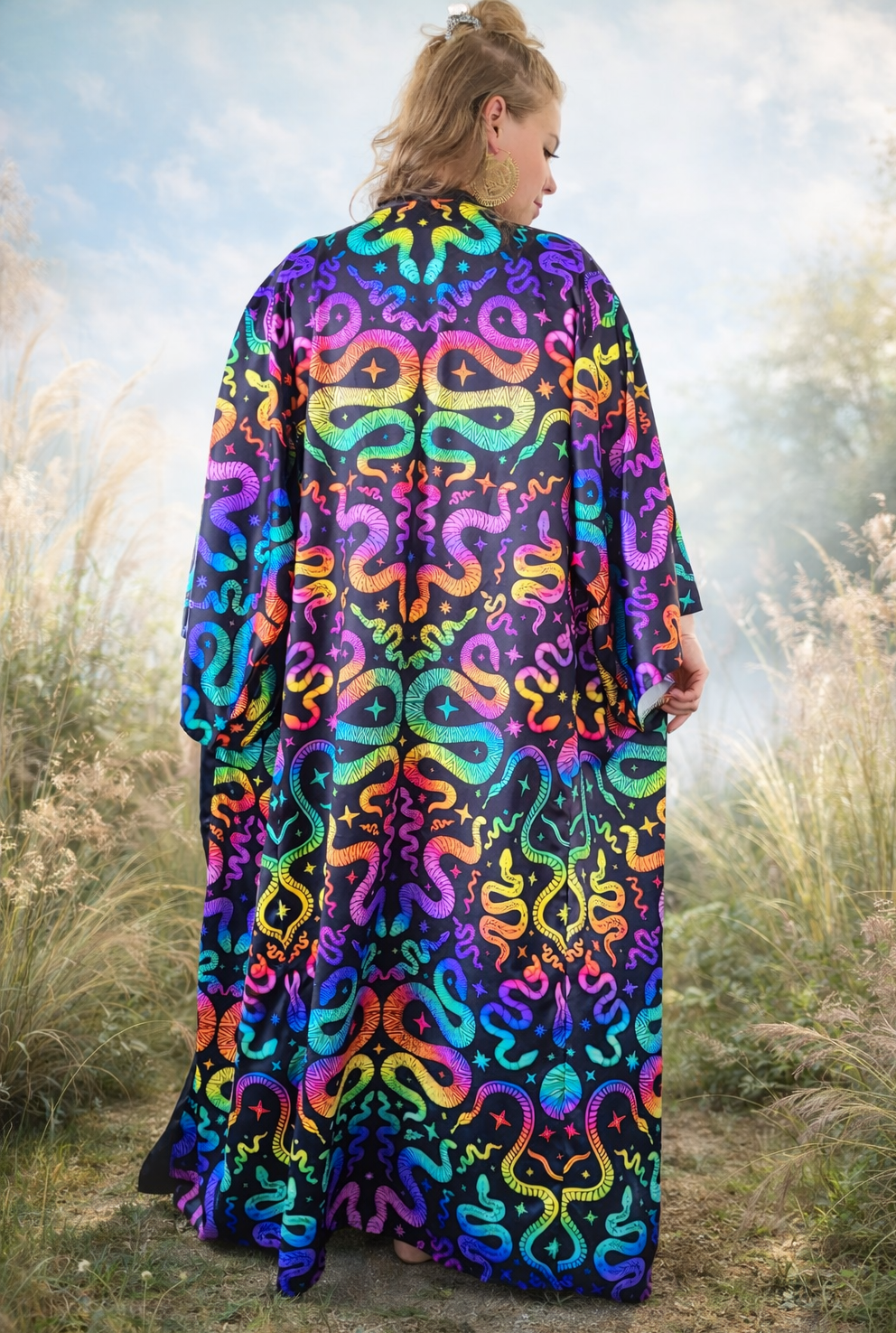 Woman wearing a colorful snake-patterned kimono standing in a natural setting.